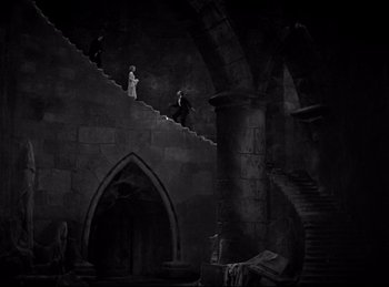 Movie still from “Dracula” (1931), directed by Tod Browning – A group of people walking down a set of stairs; Extreme Wide shot, High angle