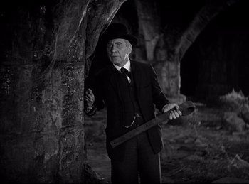 Movie still from “Dracula” (1931), directed by Tod Browning – An old man in a suit and hat holding an axe; Medium shot, High angle