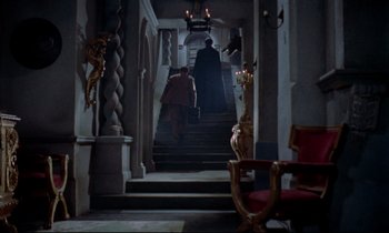 Movie still from “Horror of Dracula” (1958), directed by Terence Fisher – A man walking down the stairs of a building; Wide shot, Low angle