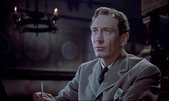 Movie still from “Horror of Dracula” (1958), directed by Terence Fisher – A person wearing a suit holding a cigarette; Close Up shot, Low angle