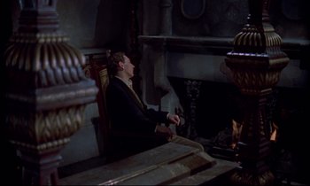 Movie still from “Horror of Dracula” (1958), directed by Terence Fisher – A man sitting in front of a fire place; Medium shot, High angle