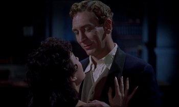 Movie still from “Horror of Dracula” (1958), directed by Terence Fisher – A man and a young woman are in a dark room; Close Up shot, Over the shoulder angle