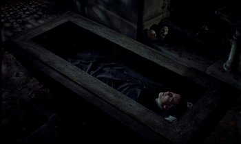 Movie still from “Horror of Dracula” (1958), directed by Terence Fisher – A man laying in a coffin in the dark; Wide shot, Overhead angle