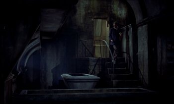 Movie still from “Horror of Dracula” (1958), directed by Terence Fisher – A man standing on the stairs of an old building; Wide shot, High angle