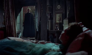 Movie still from “Horror of Dracula” (1958), directed by Terence Fisher – A man standing in front of a mirror in front of a bed; Wide shot, Over the shoulder angle