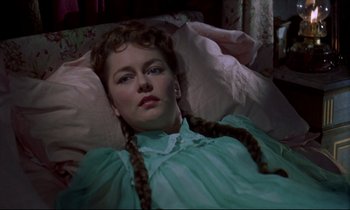 Movie still from “Horror of Dracula” (1958), directed by Terence Fisher – A woman in a green dress laying in a bed; Close Up shot, High angle