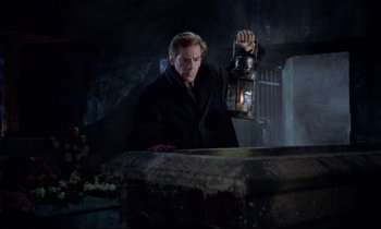 Movie still from “Horror of Dracula” (1958), directed by Terence Fisher – A man holding a lantern while standing next to a stone wall; Medium shot, Low angle