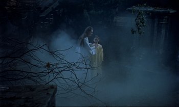 Movie still from “Horror of Dracula” (1958), directed by Terence Fisher – A woman and a child are standing in the fog; Wide shot, High angle