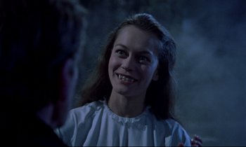 Movie still from “Horror of Dracula” (1958), directed by Terence Fisher – A young woman smiling at the camera while wearing a white dress; Close Up shot, Over the shoulder angle