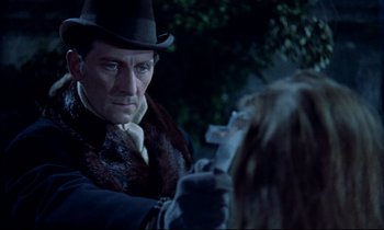Movie still from “Horror of Dracula” (1958), directed by Terence Fisher – A man in a top hat holding a gun in his hand; Close Up shot, Over the shoulder angle