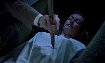 Movie still from “Horror of Dracula” (1958), directed by Terence Fisher – A man holding a knife over a woman's face; Medium shot, Overhead angle