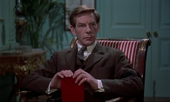 Movie still from “Horror of Dracula” (1958), directed by Terence Fisher – A man in a suit and tie sitting in a chair; Close Up shot, Over the shoulder angle