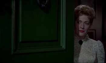 Movie still from “Horror of Dracula” (1958), directed by Terence Fisher – A woman standing in front of a green door; Close Up shot, Over the shoulder angle
