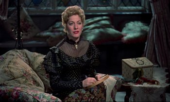 Movie still from “Horror of Dracula” (1958), directed by Terence Fisher – A woman sitting on a chair holding a book; Medium shot, Over the shoulder angle