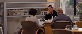 Movie still from “Drag Me to Hell” (2009), directed by Sam Raimi – A group of people sitting around a table; Medium shot, Over the shoulder angle