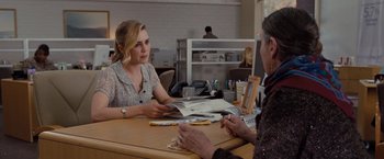 Movie still from “Drag Me to Hell” (2009), directed by Sam Raimi – Two people are sitting at a table with papers; Medium shot, Over the shoulder angle