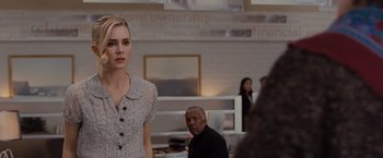 Movie still from “Drag Me to Hell” (2009), directed by Sam Raimi – A woman standing in front of a group of people; Medium shot, Over the shoulder angle