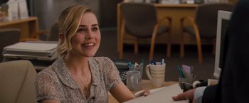 Movie still from “Drag Me to Hell” (2009), directed by Sam Raimi – A woman sitting at a table smiling for the camera; Medium shot, Over the shoulder angle