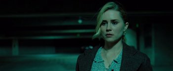 Movie still from “Drag Me to Hell” (2009), directed by Sam Raimi – A woman with blonde hair is standing in the dark; Close Up shot, Over the shoulder angle