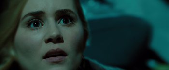 Movie still from “Drag Me to Hell” (2009), directed by Sam Raimi – A woman's face in a dark room; Close Up shot, Low angle