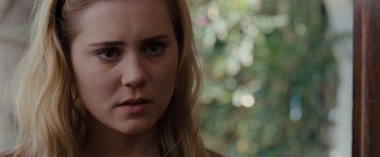 Movie still from “Drag Me to Hell” (2009), directed by Sam Raimi – A person with long blonde hair; Close Up shot, Over the shoulder angle