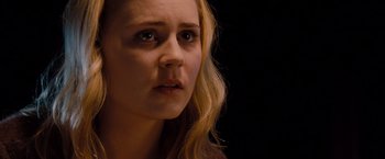Movie still from “Drag Me to Hell” (2009), directed by Sam Raimi – A person with long blonde hair; Close Up shot, Over the shoulder angle