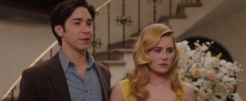 Movie still from “Drag Me to Hell” (2009), directed by Sam Raimi – A man and a woman standing next to each other in front of a staircase; Close Up shot, Over the shoulder angle