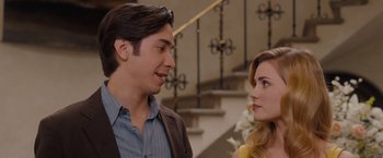 Movie still from “Drag Me to Hell” (2009), directed by Sam Raimi – A man and a woman standing next to each other in front of a staircase; Close Up shot, Over the shoulder angle