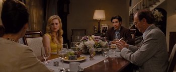 Movie still from “Drag Me to Hell” (2009), directed by Sam Raimi – A group of people sitting at a table with food; Medium shot, Over the shoulder angle