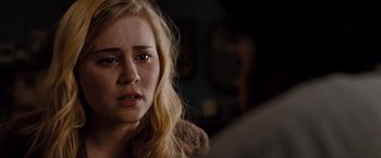 Movie still from “Drag Me to Hell” (2009), directed by Sam Raimi – A young blonde haired woman looking sad with her eyes wide open; Close Up shot, Over the shoulder angle