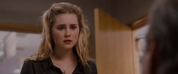 Movie still from “Drag Me to Hell” (2009), directed by Sam Raimi – A woman with long blonde hair wearing a black shirt; Close Up shot, Over the shoulder angle