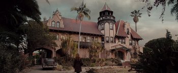 Movie still from “Drag Me to Hell” (2009), directed by Sam Raimi – A woman standing in front of a large building; Extreme Wide shot, Low angle