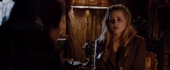 Movie still from “Drag Me to Hell” (2009), directed by Sam Raimi – A woman sitting in front of a microphone in a room; Close Up shot, Over the shoulder angle