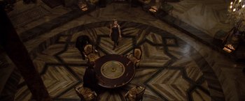 Movie still from “Drag Me to Hell” (2009), directed by Sam Raimi – A group of people sitting around a round table; Wide shot, Overhead angle