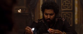 Movie still from “Drag Me to Hell” (2009), directed by Sam Raimi – A man with a beard is looking at a cigarette pack; Close Up shot, Over the shoulder angle