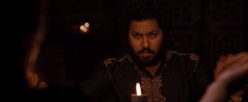 Movie still from “Drag Me to Hell” (2009), directed by Sam Raimi – A man with a beard is holding a lit candle; Close Up shot, Over the shoulder angle