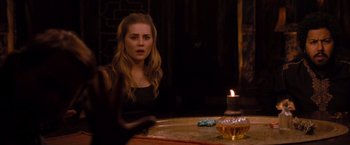 Movie still from “Drag Me to Hell” (2009), directed by Sam Raimi – A woman sitting in front of a candle on top of a table; Medium shot, Over the shoulder angle