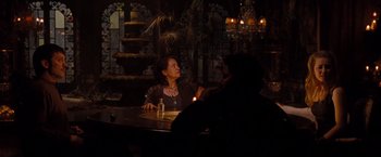 Movie still from “Drag Me to Hell” (2009), directed by Sam Raimi – A woman sitting at a table in a dark room; Wide shot, Over the shoulder angle