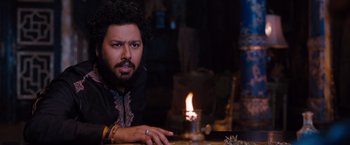 Movie still from “Drag Me to Hell” (2009), directed by Sam Raimi – A man sitting in front of a lit candle on top of a table; Close Up shot, Over the shoulder angle