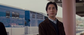 Movie still from “Drag Me to Hell” (2009), directed by Sam Raimi – A man standing in front of a blue train; Close Up shot, Over the shoulder angle