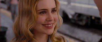 Movie still from “Drag Me to Hell” (2009), directed by Sam Raimi – A person with a smile on their face; Close Up shot, Over the shoulder angle