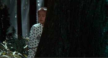 Movie still from “Dreams” (1990), directed by Akira Kurosawa – A young boy standing next to a tree; Medium shot, High angle