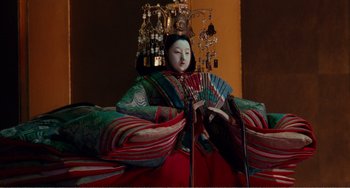 Movie still from “Dreams” (1990), directed by Akira Kurosawa – A doll with a fan sitting on top of it's head; Medium shot, Low angle