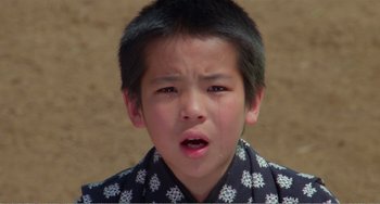 Movie still from “Dreams” (1990), directed by Akira Kurosawa – A young asian boy crying with his eyes wide open; Close Up shot, High angle