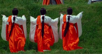 Movie still from “Dreams” (1990), directed by Akira Kurosawa – A group of people sitting on the grass; Wide shot, High angle