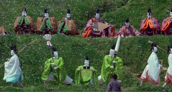 Movie still from “Dreams” (1990), directed by Akira Kurosawa – A group of people dressed in costumes sitting in the grass; Extreme Wide shot, High angle
