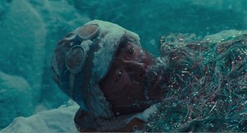 Movie still from “Dreams” (1990), directed by Akira Kurosawa – A man wearing a winter hat swimming in the water; Close Up shot, High angle
