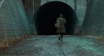 Movie still from “Dreams” (1990), directed by Akira Kurosawa – A person walking in front of an entrance to a tunnel; Wide shot, Low angle