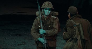 Movie still from “Dreams” (1990), directed by Akira Kurosawa – A man in a uniform holding a rifle in his hands; Medium shot, Over the shoulder angle
