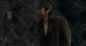 Movie still from “Dreams” (1990), directed by Akira Kurosawa – A man wearing a hat and a trench coat; Medium shot, Low angle